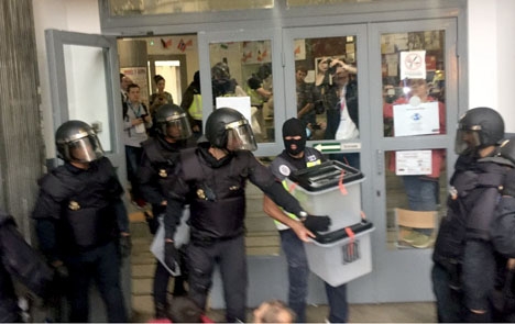 Kravallpoliser beslagtar valurnor under söndagsförmiddagen. Foto: CatalanReferendum 