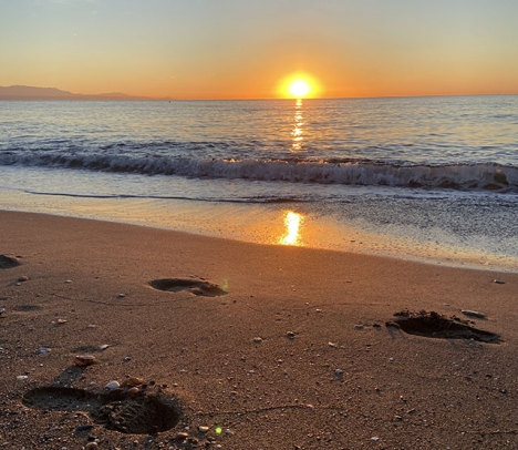 Att välkomna solen vid stranden när den stiger upp över havet är en perfekt start på dagen.