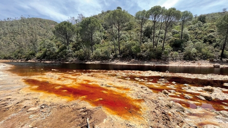 Riotinto betyder den rödfärgade ån. Mineraler som järnoxid färgar vattnet och lockar turister, men risken uppges vara övervägande för att ett utsläpp av en rad andra mineraler från gruvdriften ska orsaka en ny miljökatastrof i Andalusien.