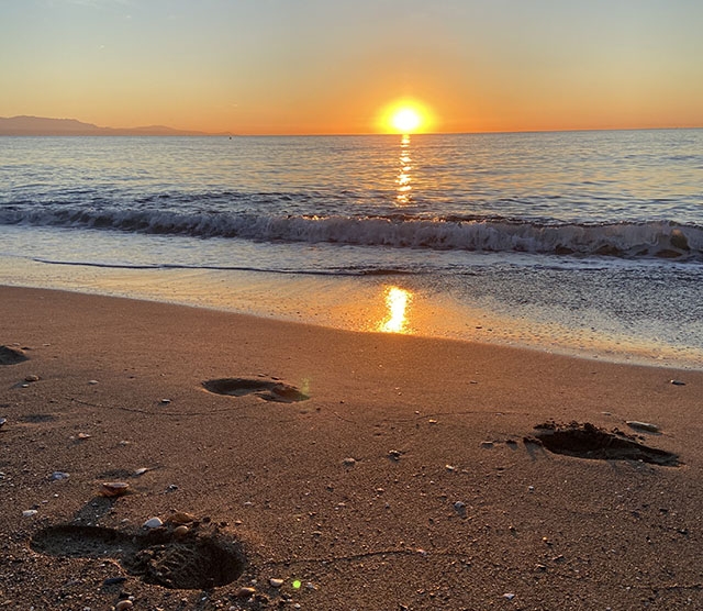 Att välkomna solen vid stranden när den stiger upp över havet är en perfekt start på dagen.