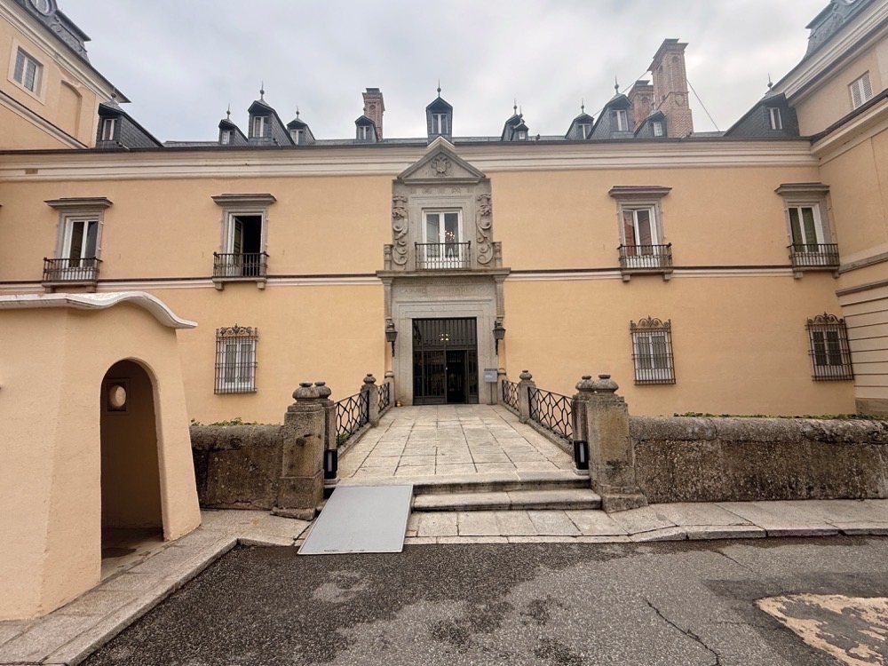 Över den valvformade huvudporten sitter en stenhuggen inskription från 1547 som fortfarande bär kejsar Carlos V:s namn och titel, ett av de tydligaste spåren av palatsets äldsta byggnadsskede.